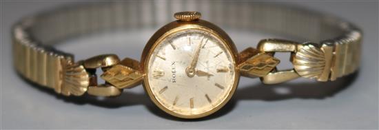 A ladies 18ct gold Rolex manual wind wrist watch, on an associated gold plated flexible strap.